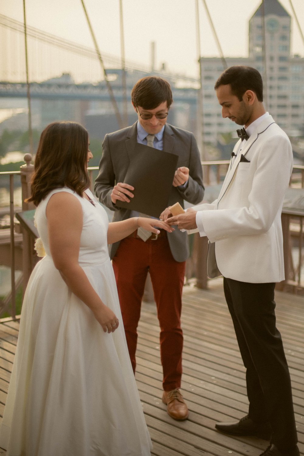 Witness the joy and laughter as Brett, an NYC officiant, officiates a quick ceremony on the BrooklynBridge, followed by celebratory shots of 7am whiskey