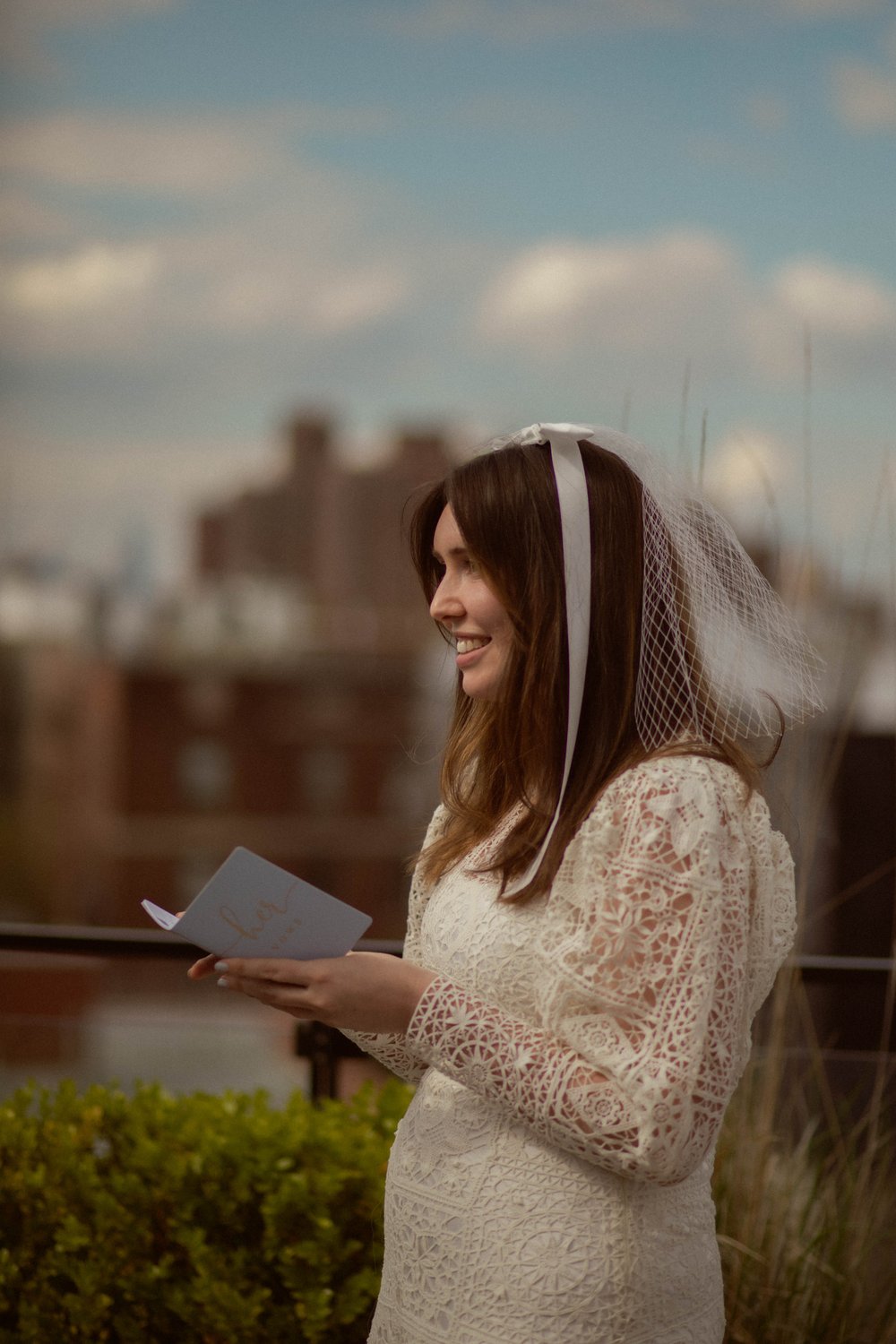 70's inspired vintage wedding dress on a bride while she reads her vows