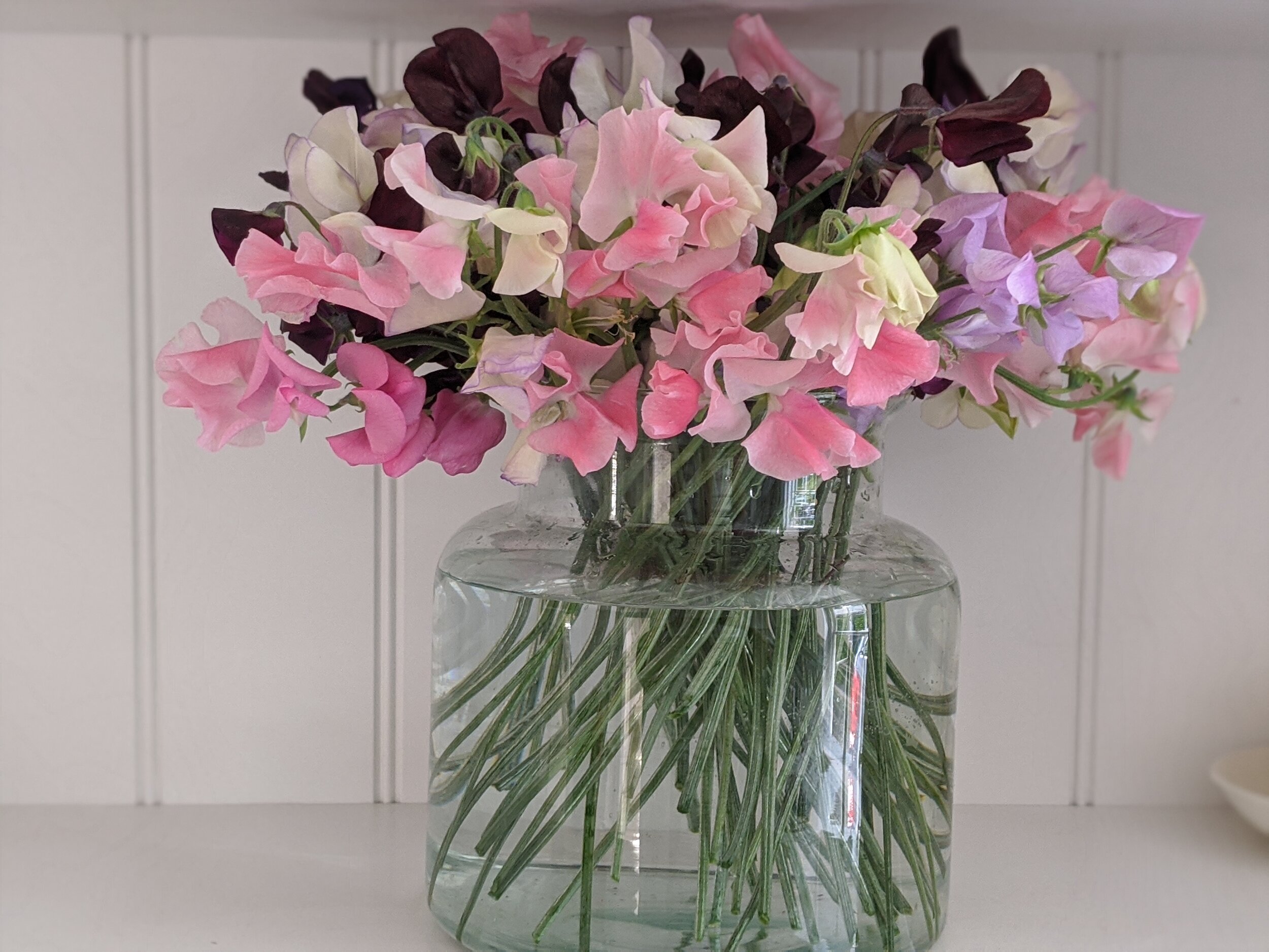 Glass vases filled with seasonal flowers from £45