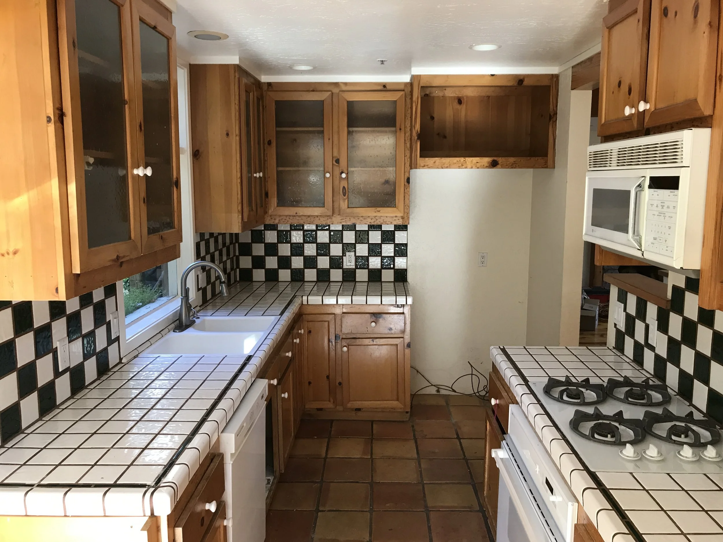  The old kitchen was closed off from the rest of the house with a full height wall. The new layout has the sink at the back wall where the refrigerator used to be.  