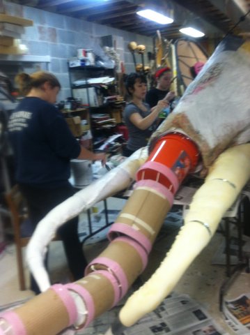 STEAMPUNK MAMMOTH  GIANT PUPPET HEAD:  Dream play: works in        progress, final form with         white undercoat: chicken wire, wood frame, tubes, buckets, paper and cloth mache, mixed materials