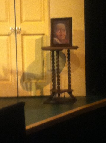 RIGGED PORTRAIT: A Little Night Music: rigged so a knife, supposedly thrown, springs out of the eye; wood, springs, duplicate knife handles, steel wire, pulleys, picture frame. Final Version on stage