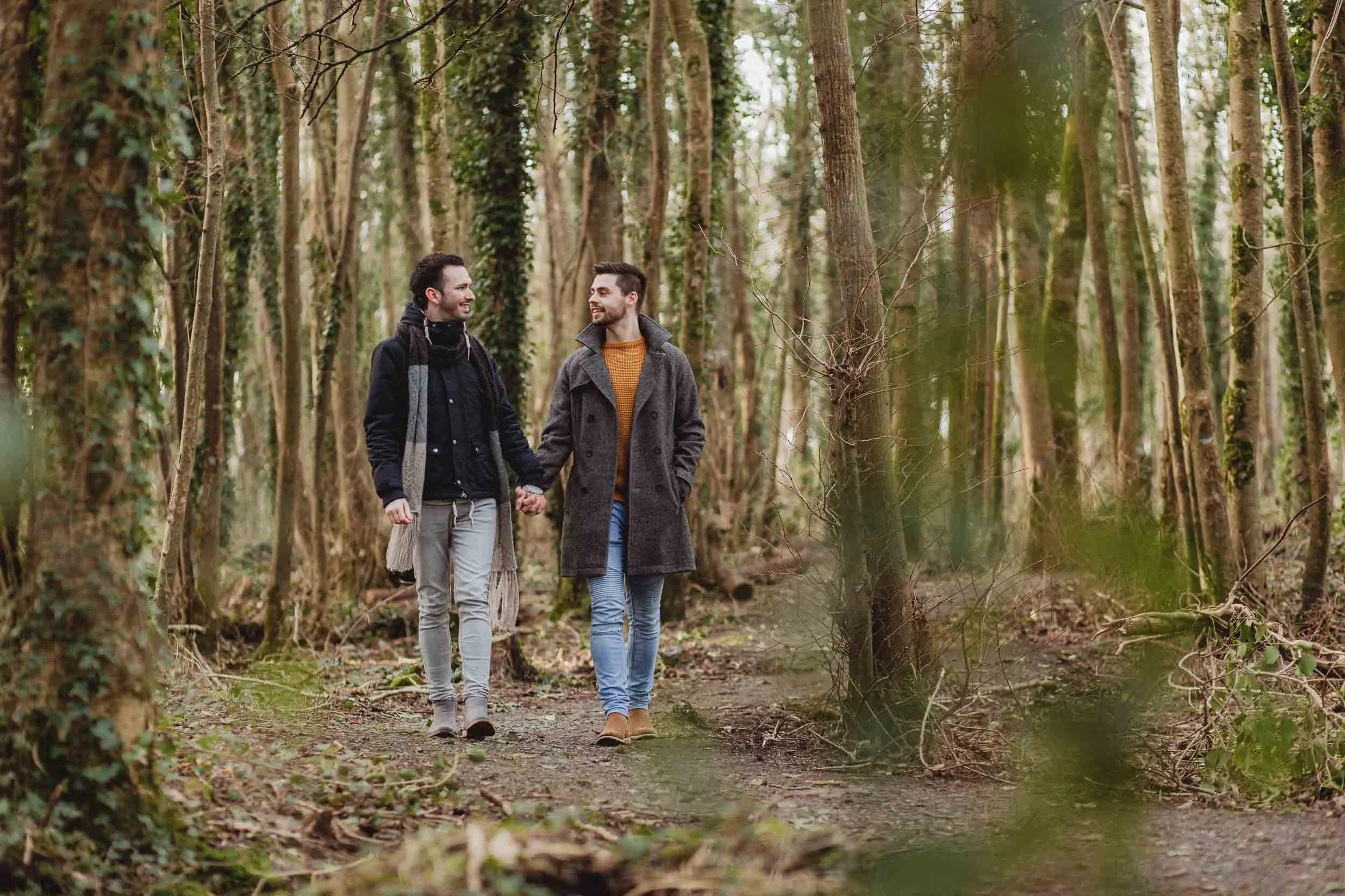 gay couple walking in a forest in galway