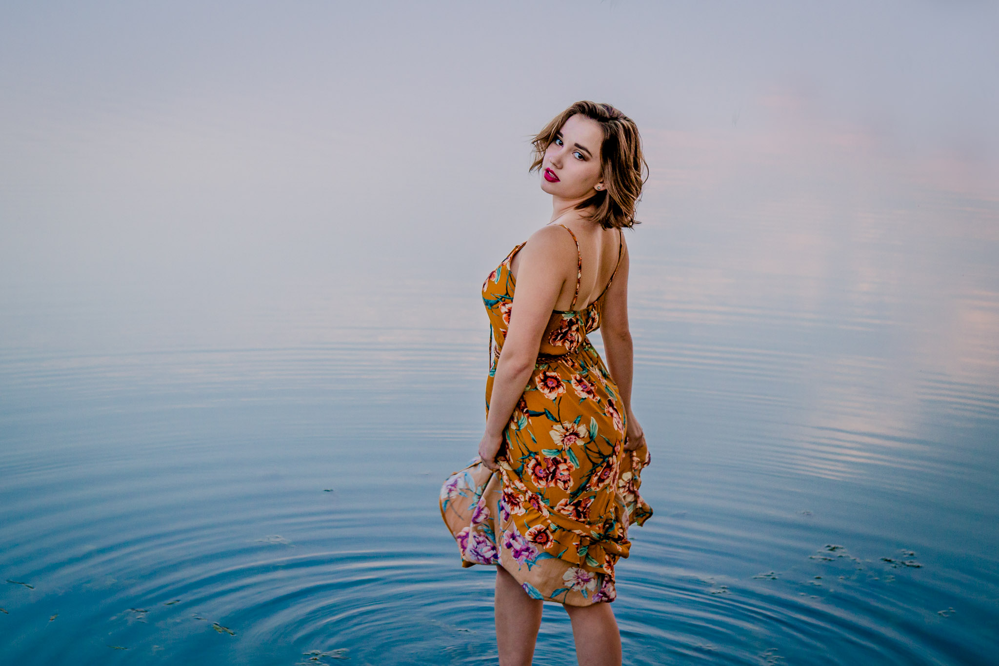 senior photo in the water at sunset