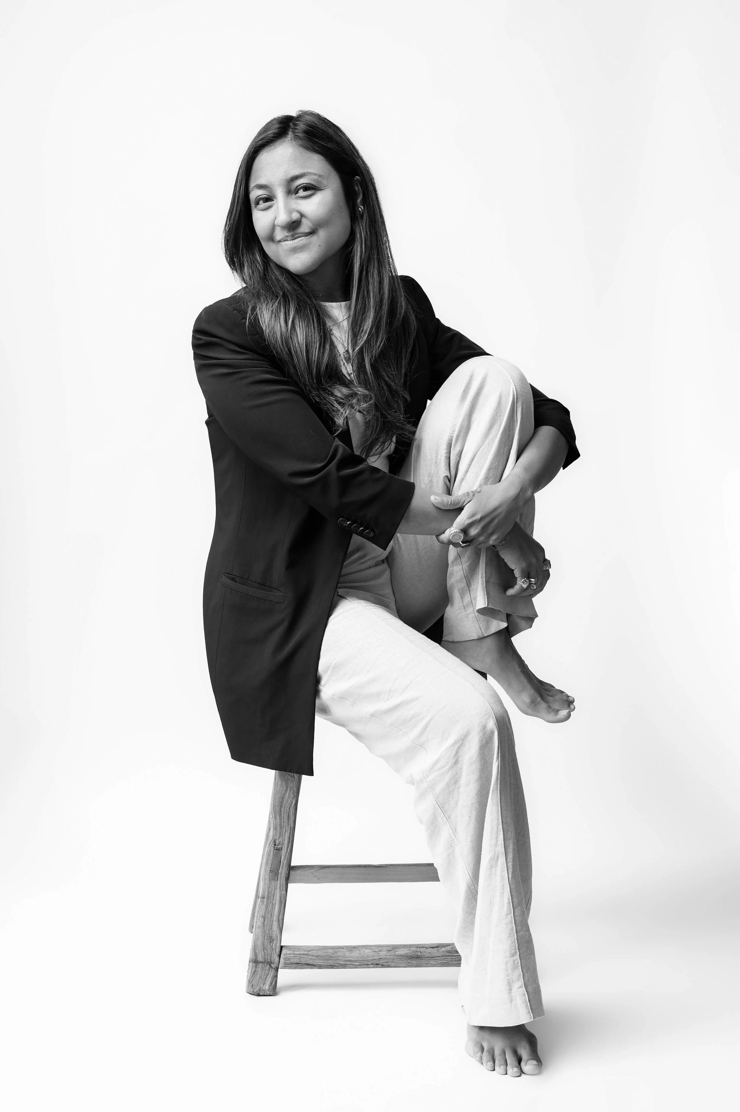 Black and white studio portrait of Cecilia Ponce on a wooden stool — personal branding photography by Daniel Ponce, San Francisco