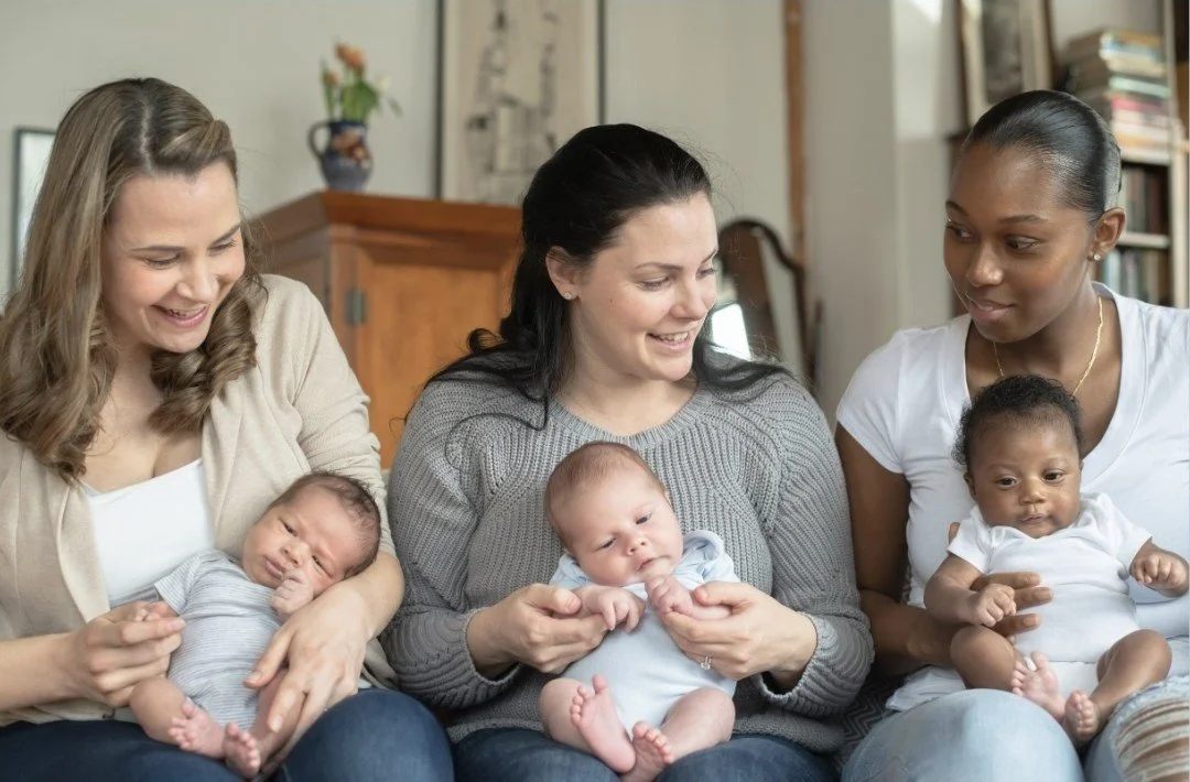 three young women of varying ethnicity with their babies on their laps