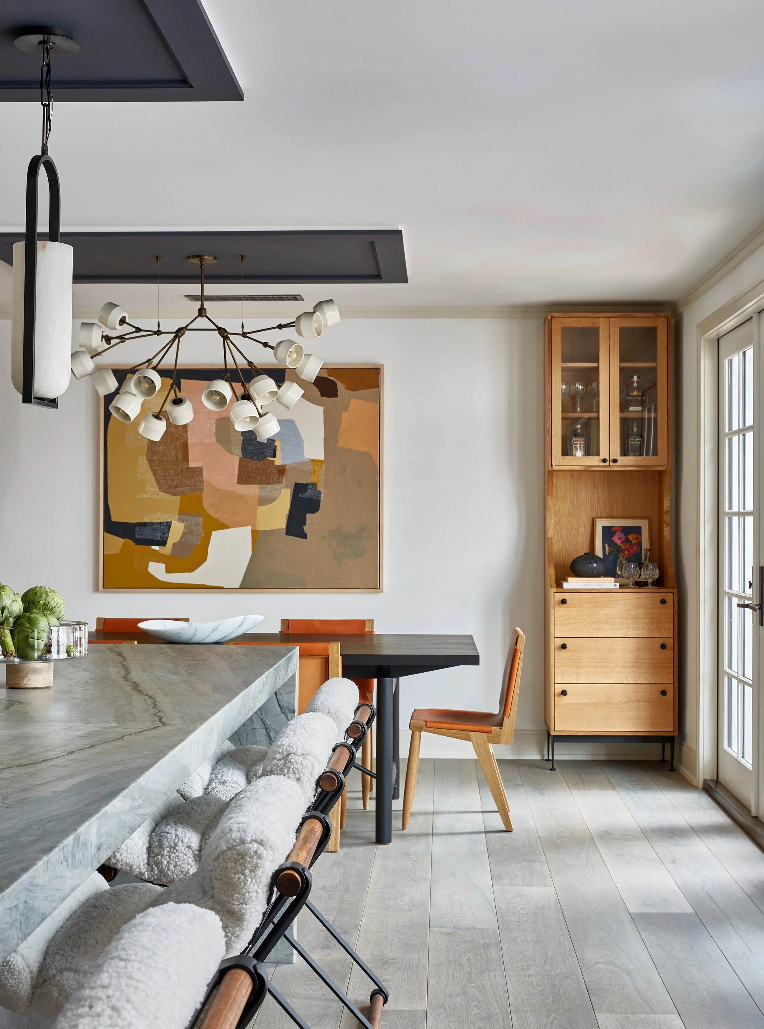 If we can call ourselves interior design magicians, decorative lighting is one of the best tricks up our sleeves. When we first met this kitchen, the dining area was adorned with a glorified pool hall box pendant (swipe for the "before" pho