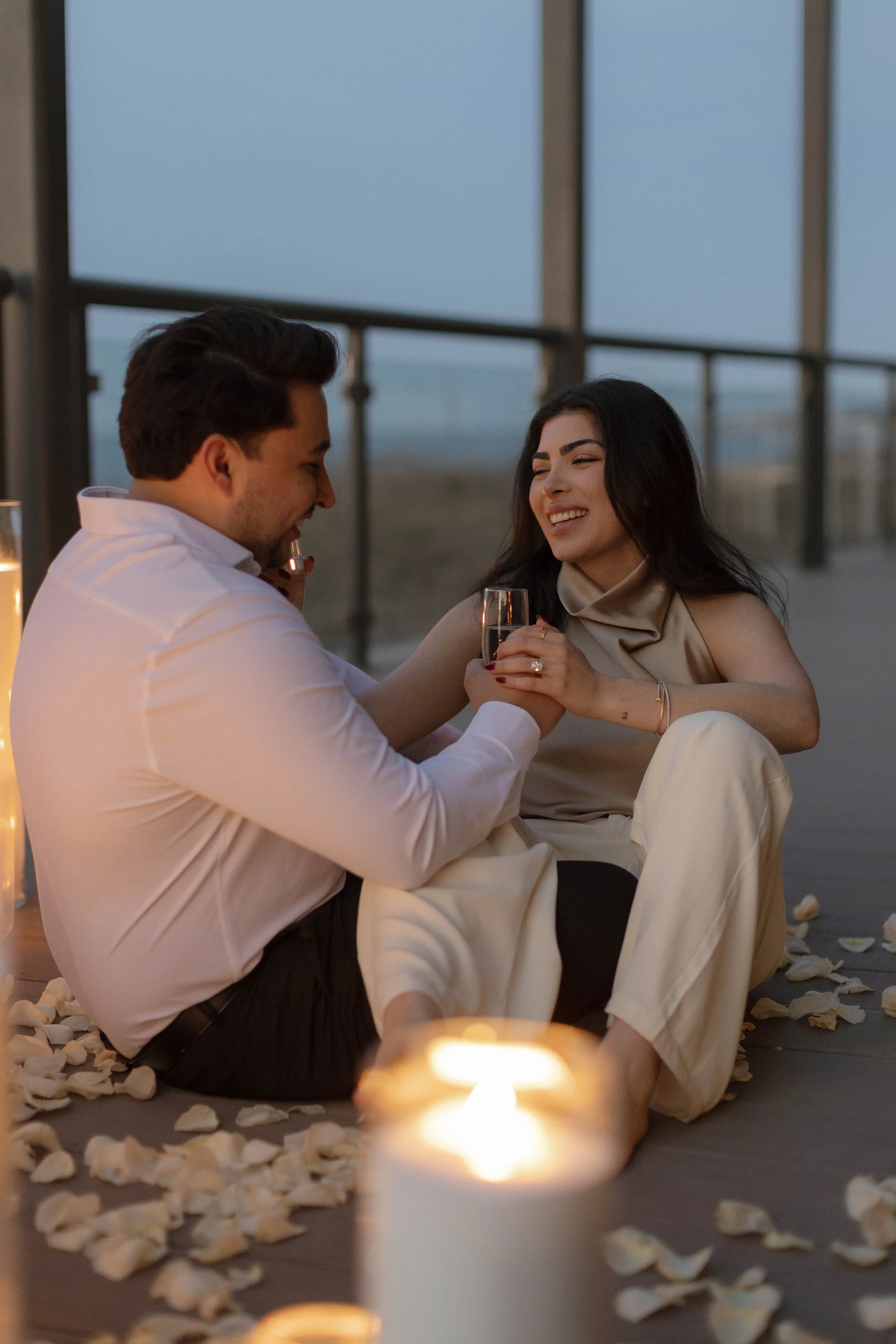 Candle-lit engagement proposal in Virginia Beach featuring a dramatic display of florals and candles overlooking the ocean