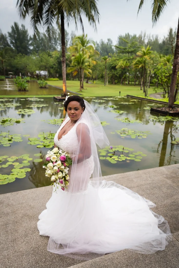 THE BRIDE Ariel is wearing a customized 'Jayla' wedding gown, with a detachable whimsy skirt (not pictured), and veil, all from Pantora Inc. in Brooklyn, New York. The bouquet was provided by the Sarojin team. For optimum elephant climbing, and waterfall hiking Ariel is wearing sneakers from Keds. Hair and make up was done by the bride. 