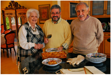 At my home, serving my parents the green lasagne I made for my father’s birthday.