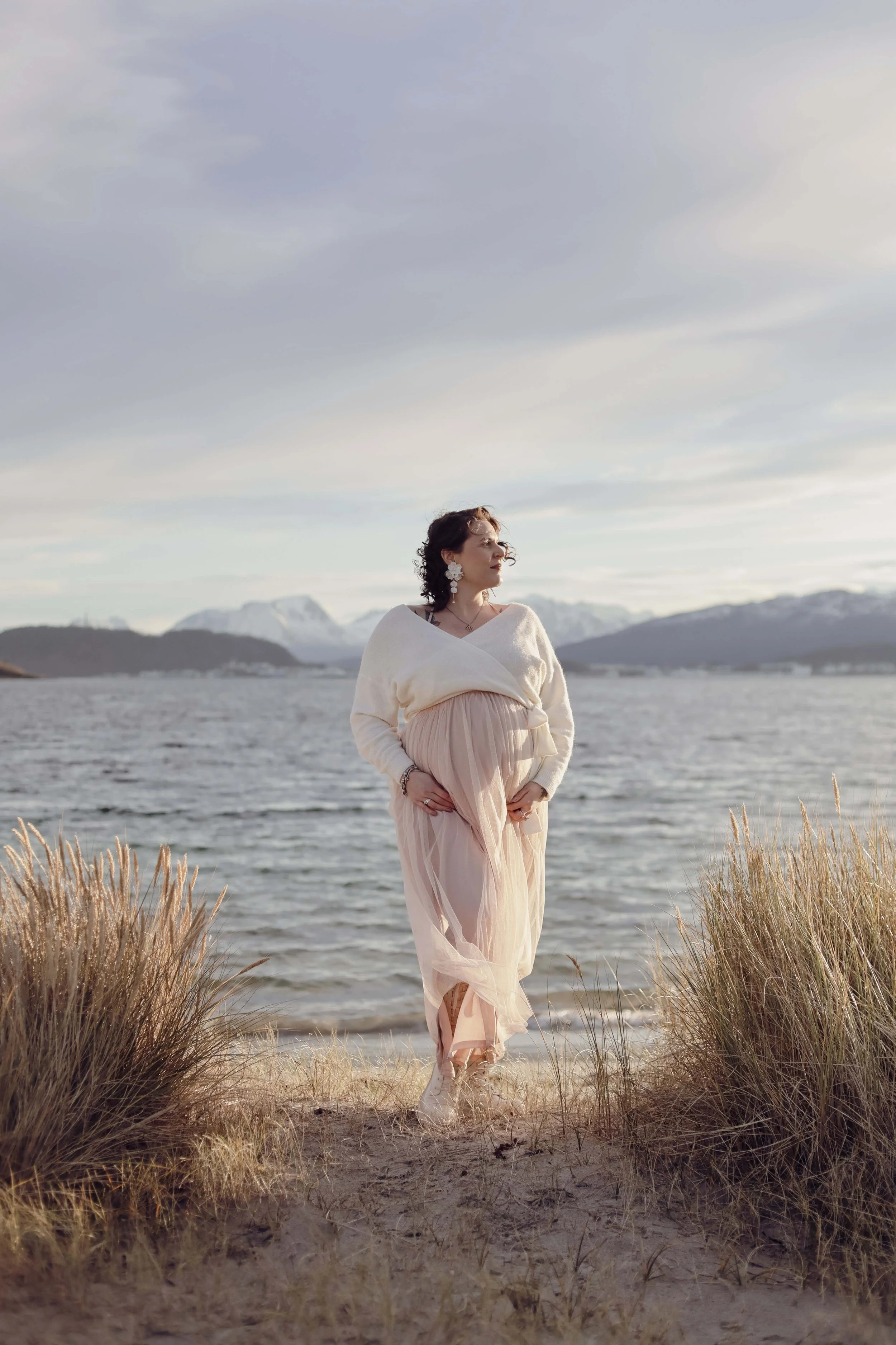  beautiful and natural picture of pregnent women on the Giske beach, mountains, sun and sea in the background 