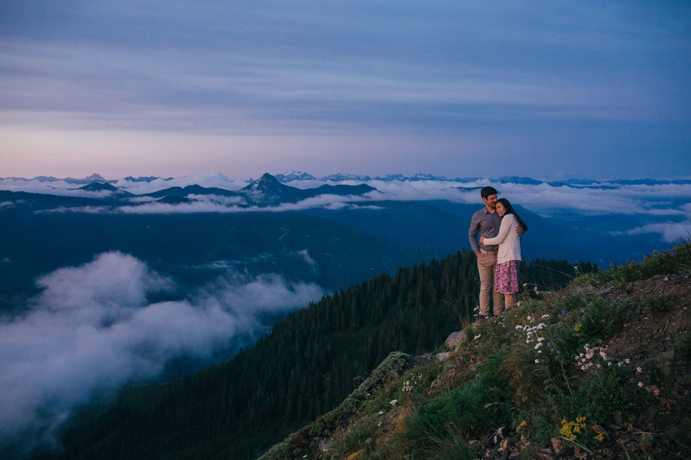 An adventurous couple embraces while on the top of Evergreen Mountain Lookout in Washington