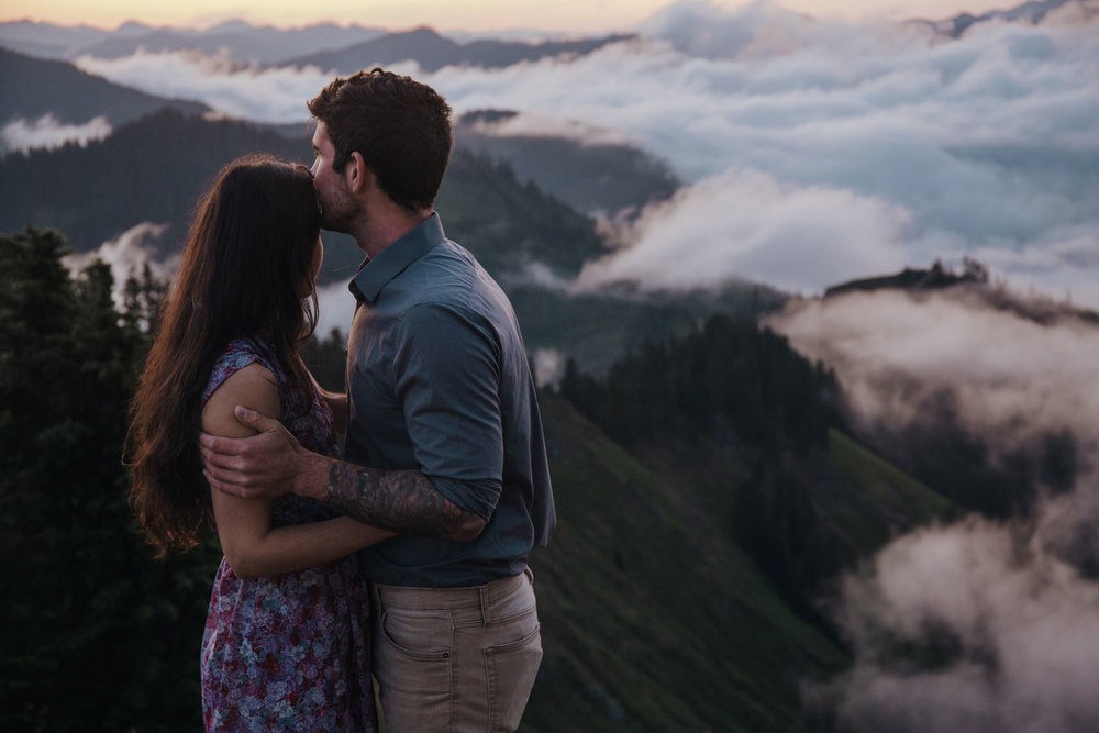 An adventurous couple watching the sunrise at the top of Evergreen Mountain Lookout in Washington