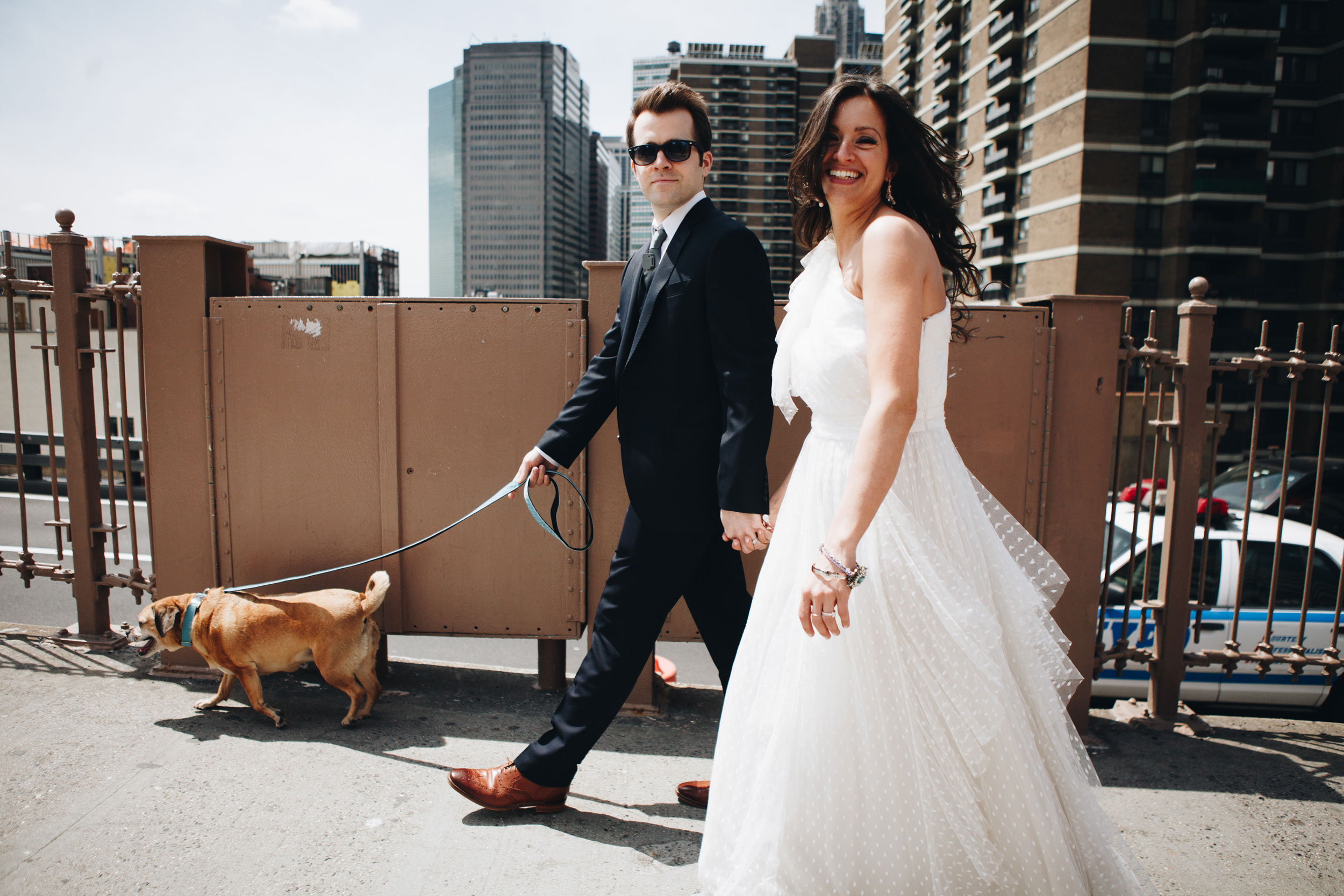 A bride and groom getting their portraits taken on the Brooklyn Bridge