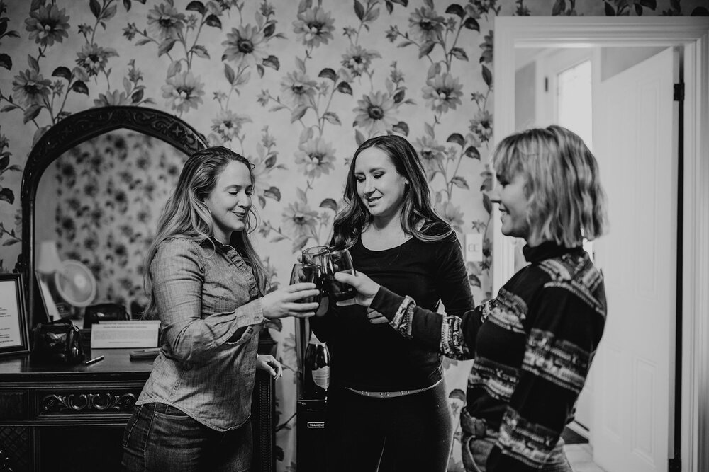 Bride and bridesmaids toast while getting ready