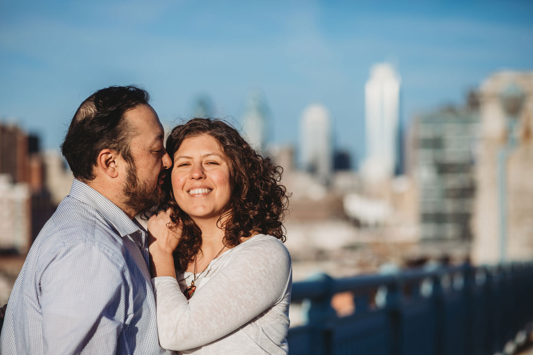 A couple posing in front of the Philadelphia skyline