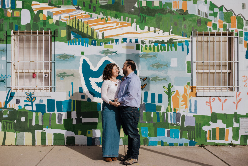 A couple standing in front of a mural in Northern Liberties
