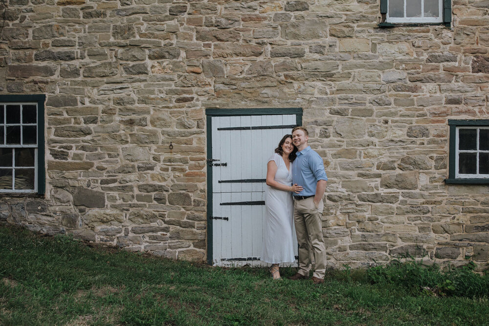 A couple posing infront of an old stone building