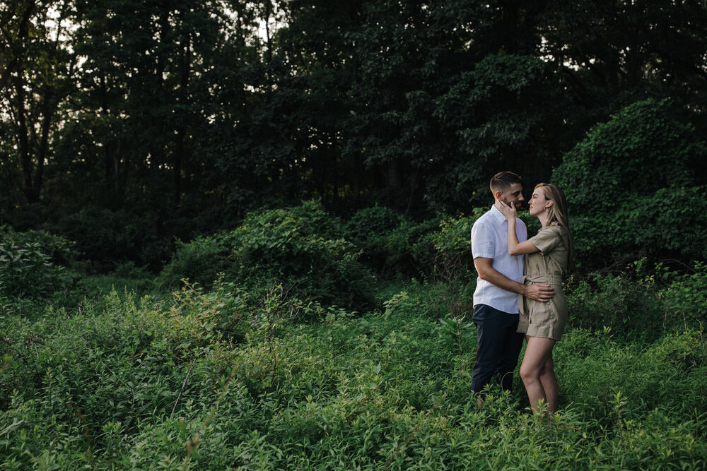 An engaged couple embracing in the woods of Pennsylvania