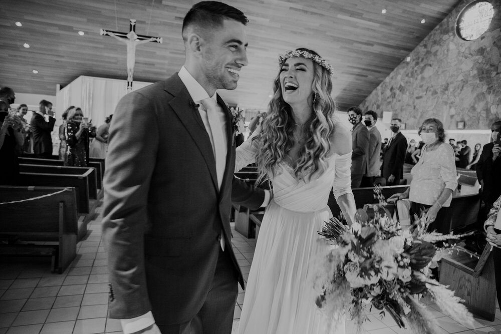 A bride and groom laughing after their ceremony