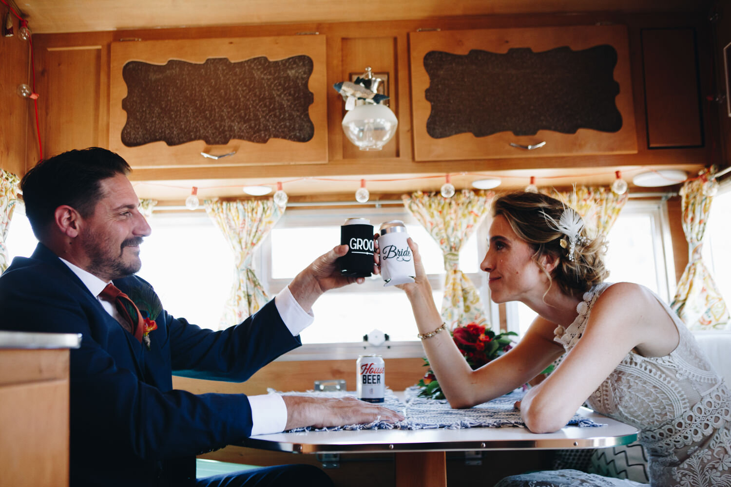 bride and groom toating with beer cans during their first look