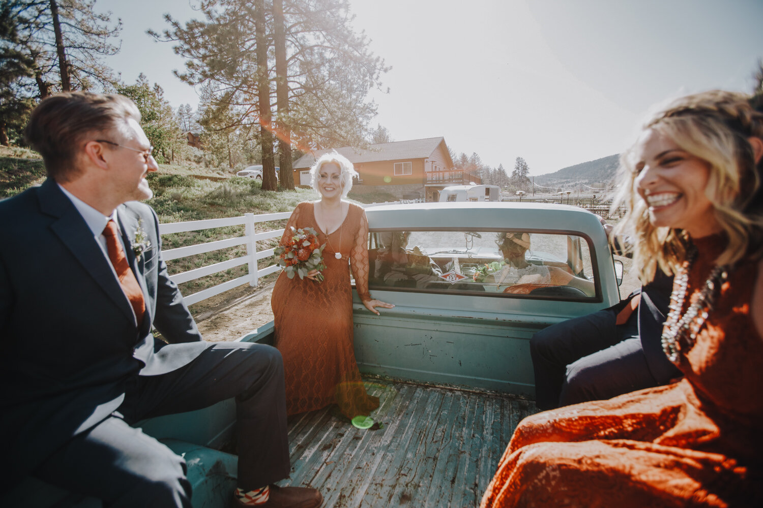 Bridal party rising in the back of a vintage pickup truck on the way to an intimate wedding ceremony in Califronia