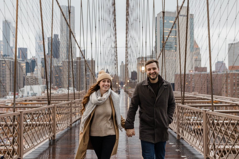 Engaged couple walking on the Brooklyn Bridge