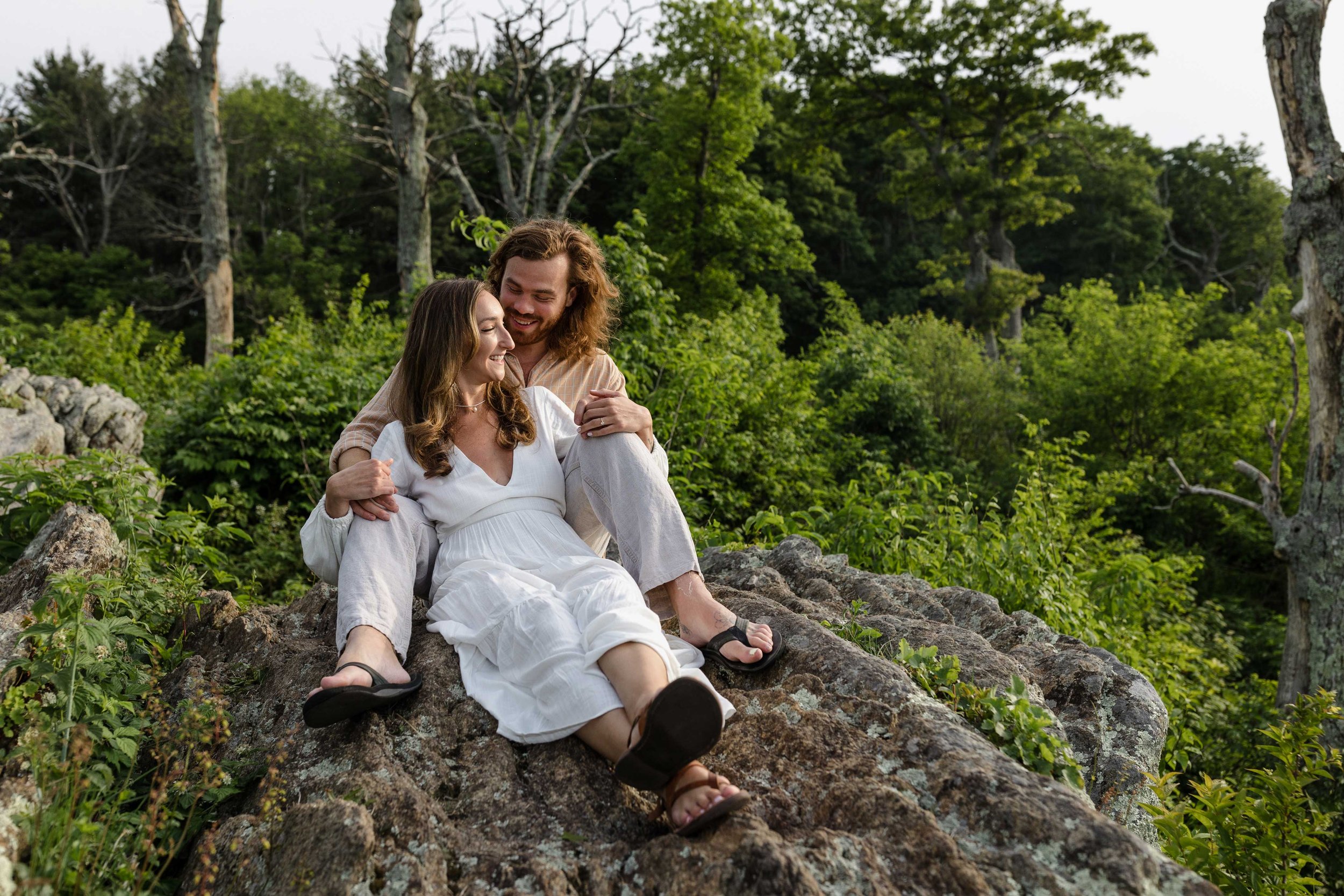 couple sitting on a rock during an engagement shoot at Shenandoah National Park