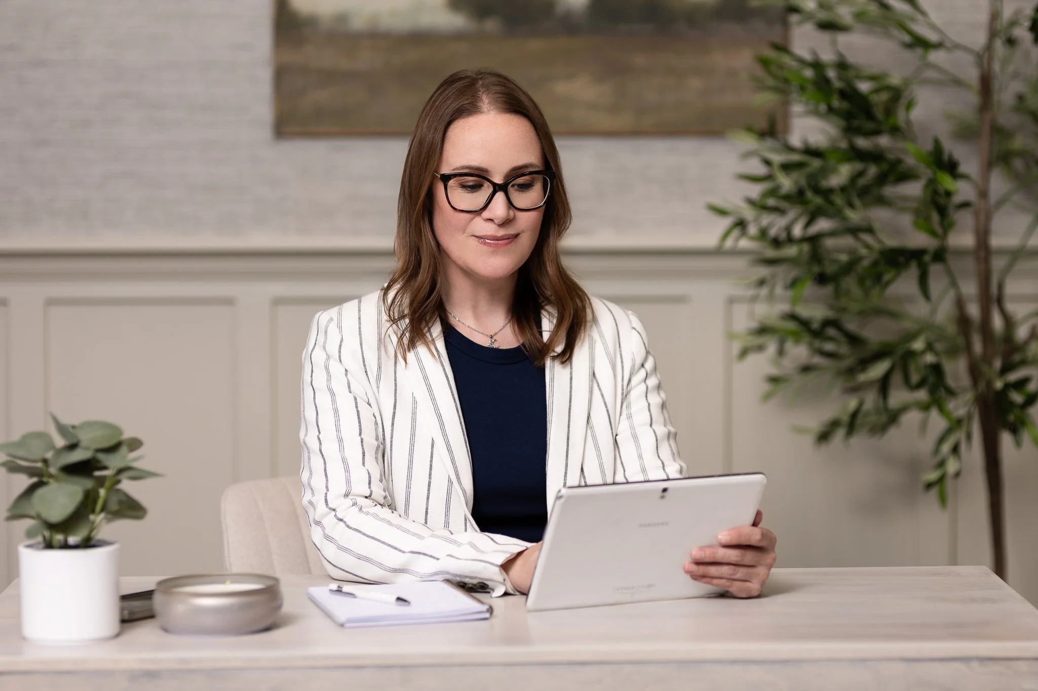 business owner sitting at desk responding to emails on ipad