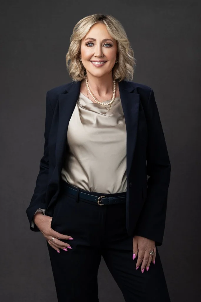 Professional medical provider smiling in a navy suit during a studio headshot session in Boise, Idaho