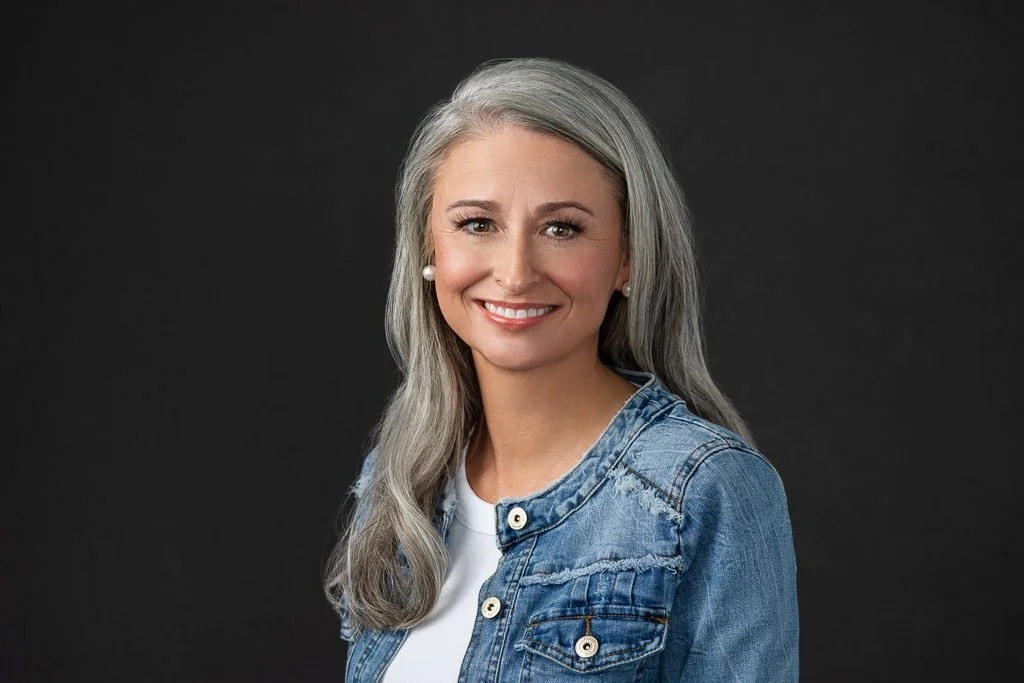 dark gray backdrop for women's headshot wearing a jean jacket