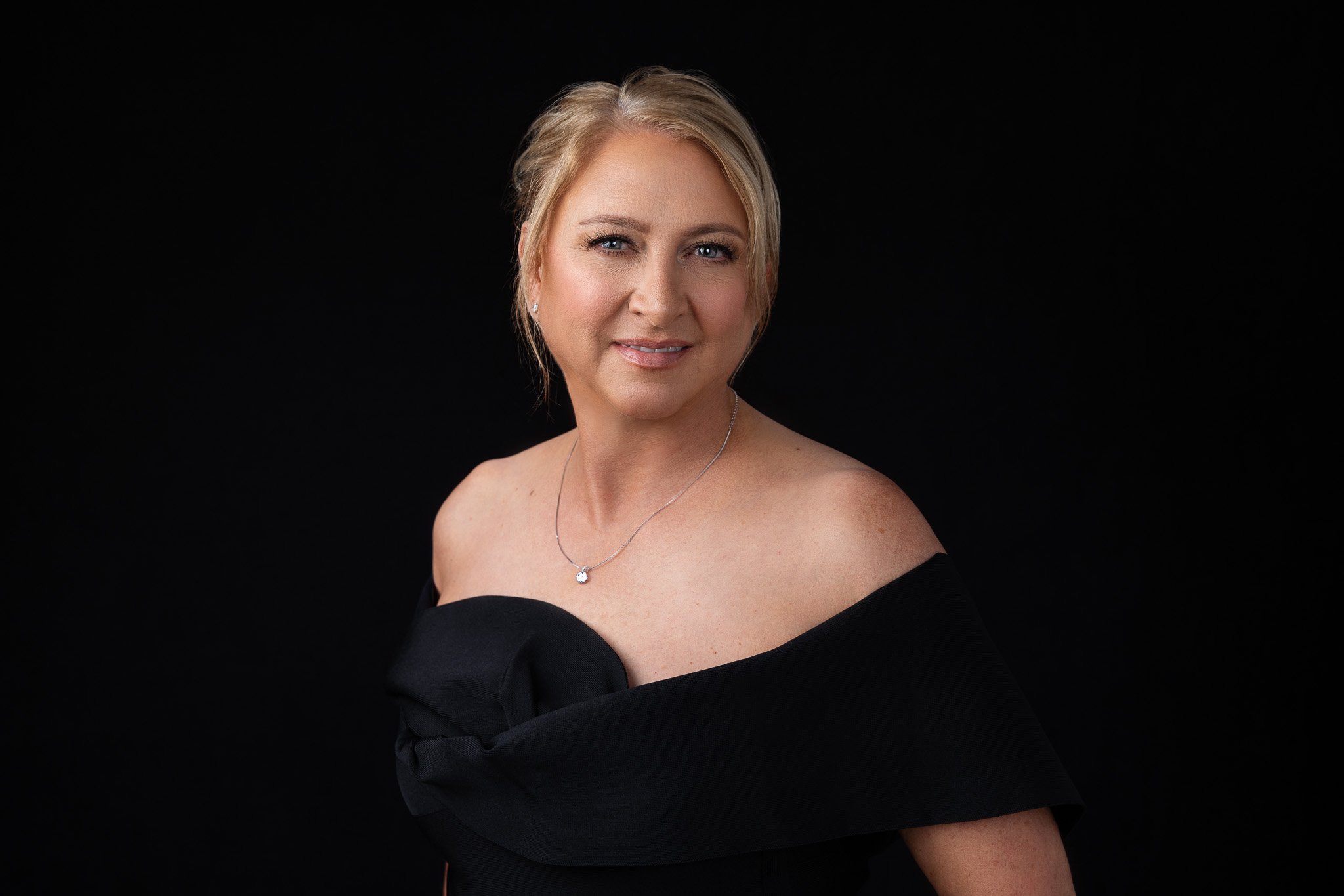 Professional headshot on a black studio background