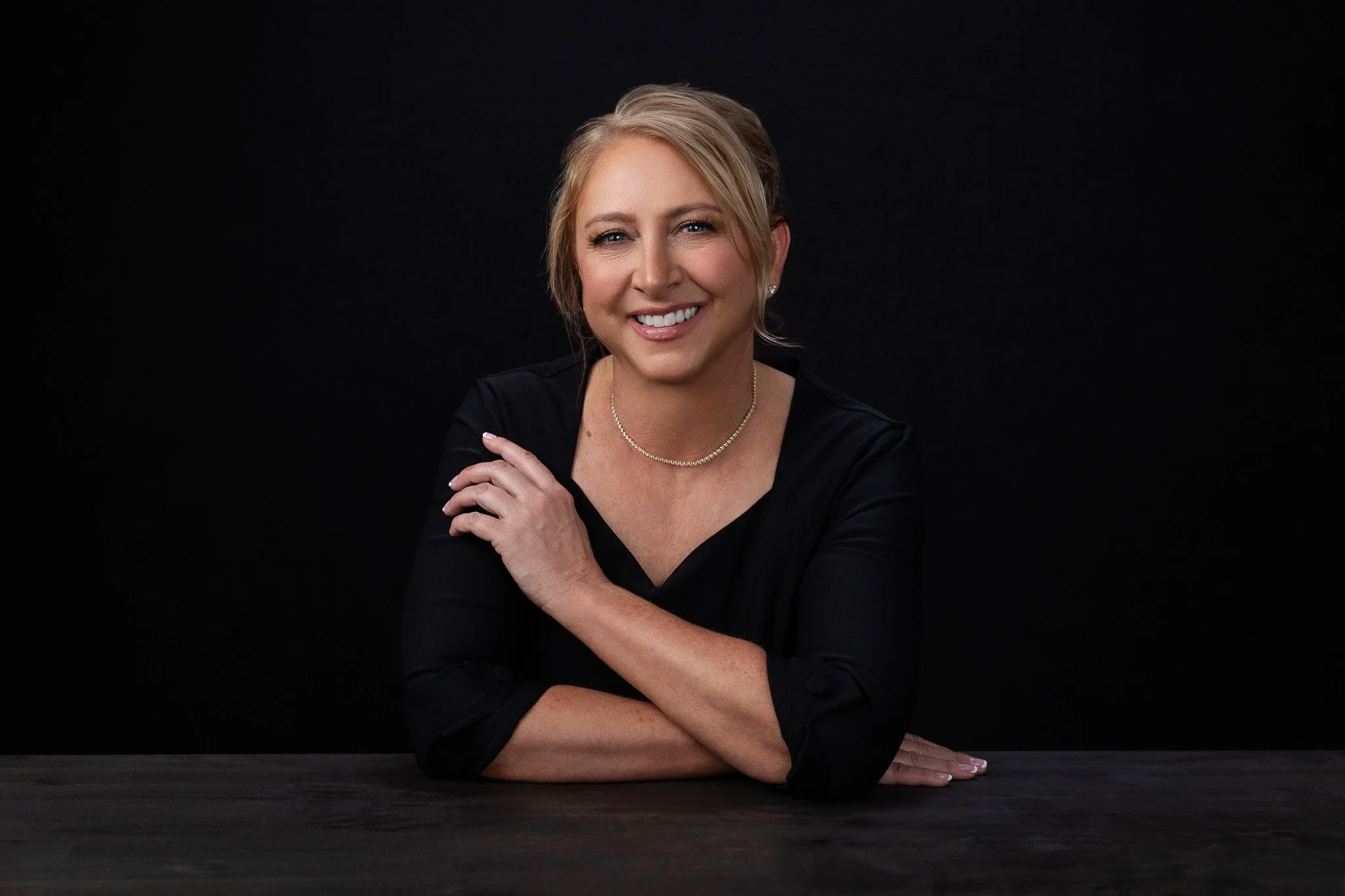 Casual professional portrait with a dark studio background