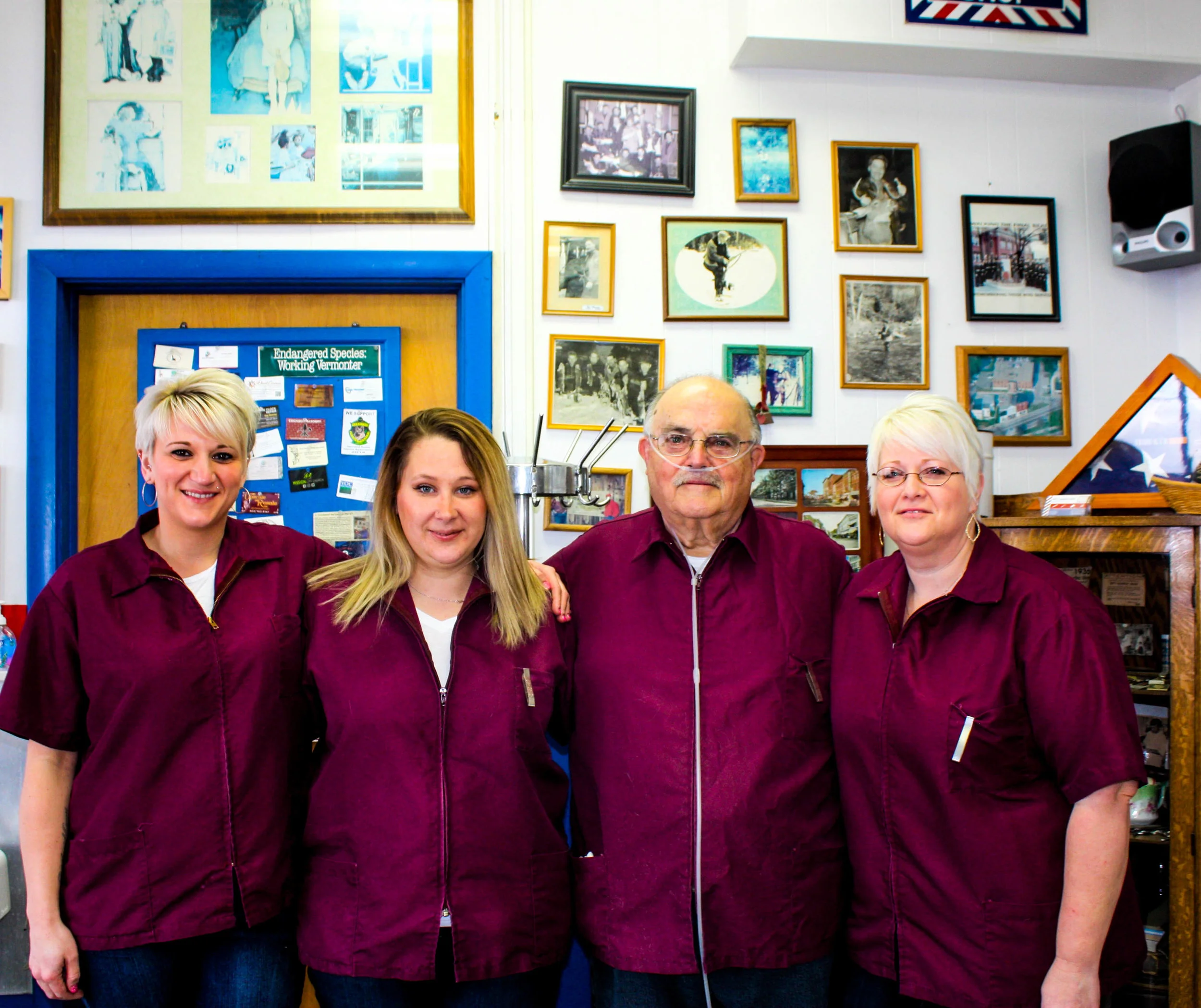 Barbers Alex Harrison, Sarah Sheldrick, and Jessica Reynolds stand with Marty Muscatello in Pip’s.