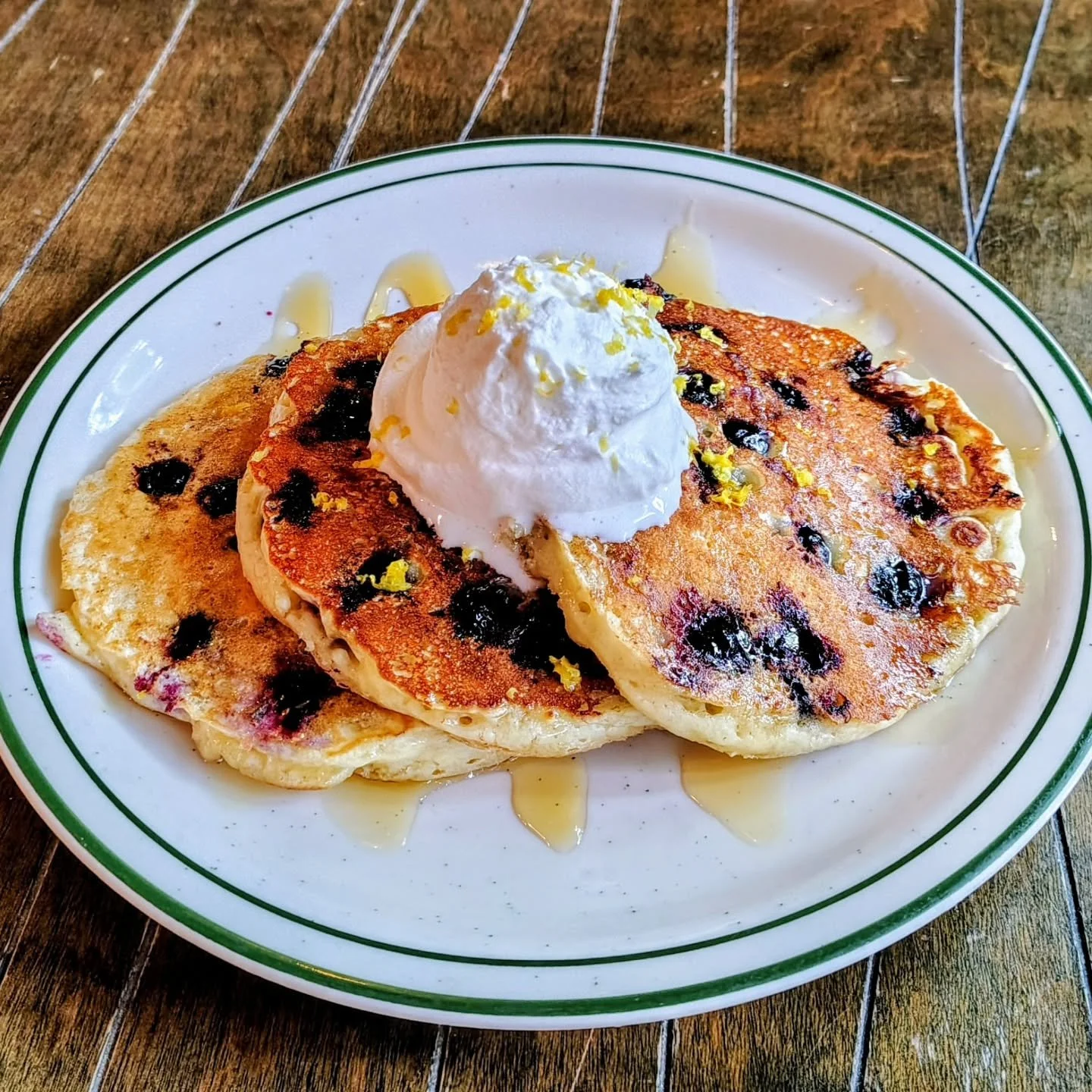 Our breakfast special, three buttermilk pancakes with Rhonda's blueberries, all natural honey drizzle, with House made Chantilly cream, topped with lemon zest