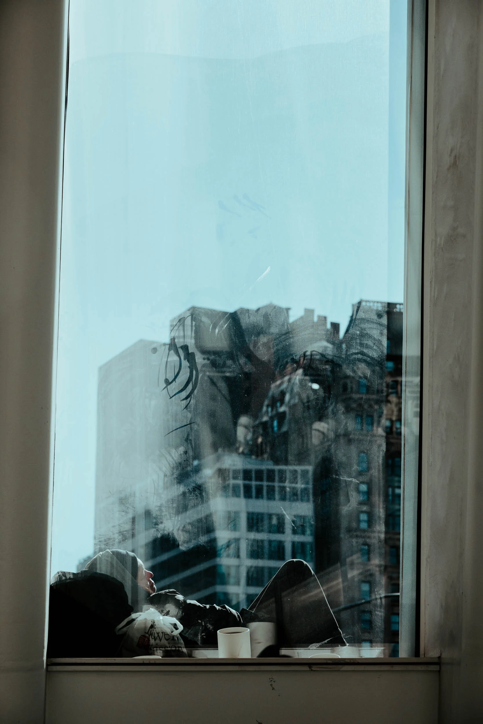  As seen from inside The Oculus, the same woman rests against her bags and blankets. 