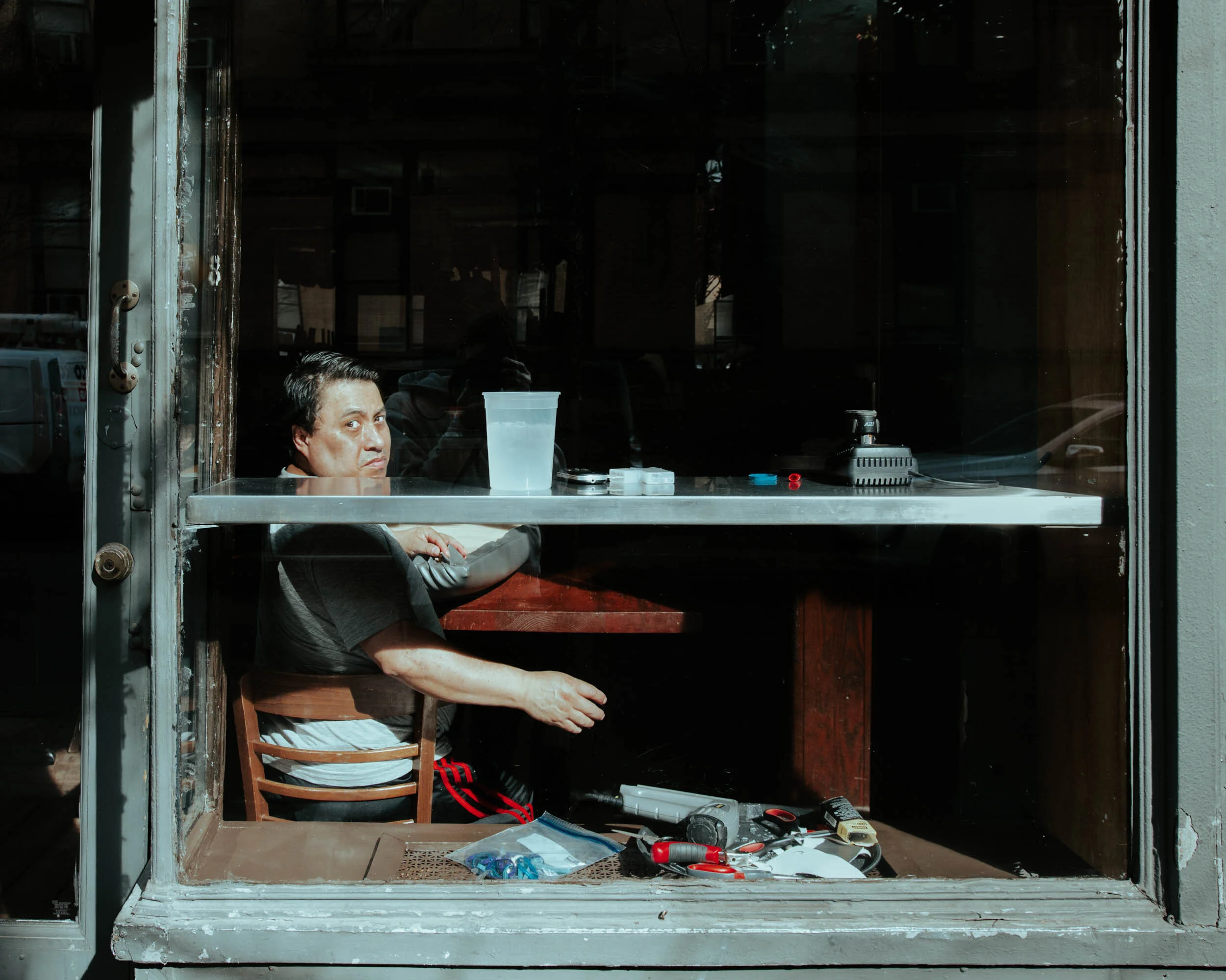  Unable to seat customers, a worker in Manhattan’s Extra Virgin makes repairs to the upholstery of the restaurant's seating. 