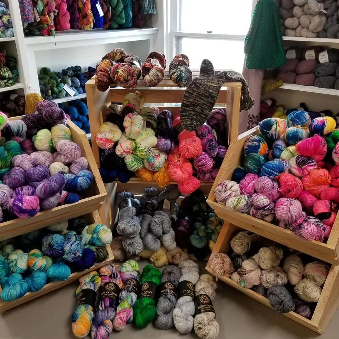 Many skeins arranged on shelves in a shop.