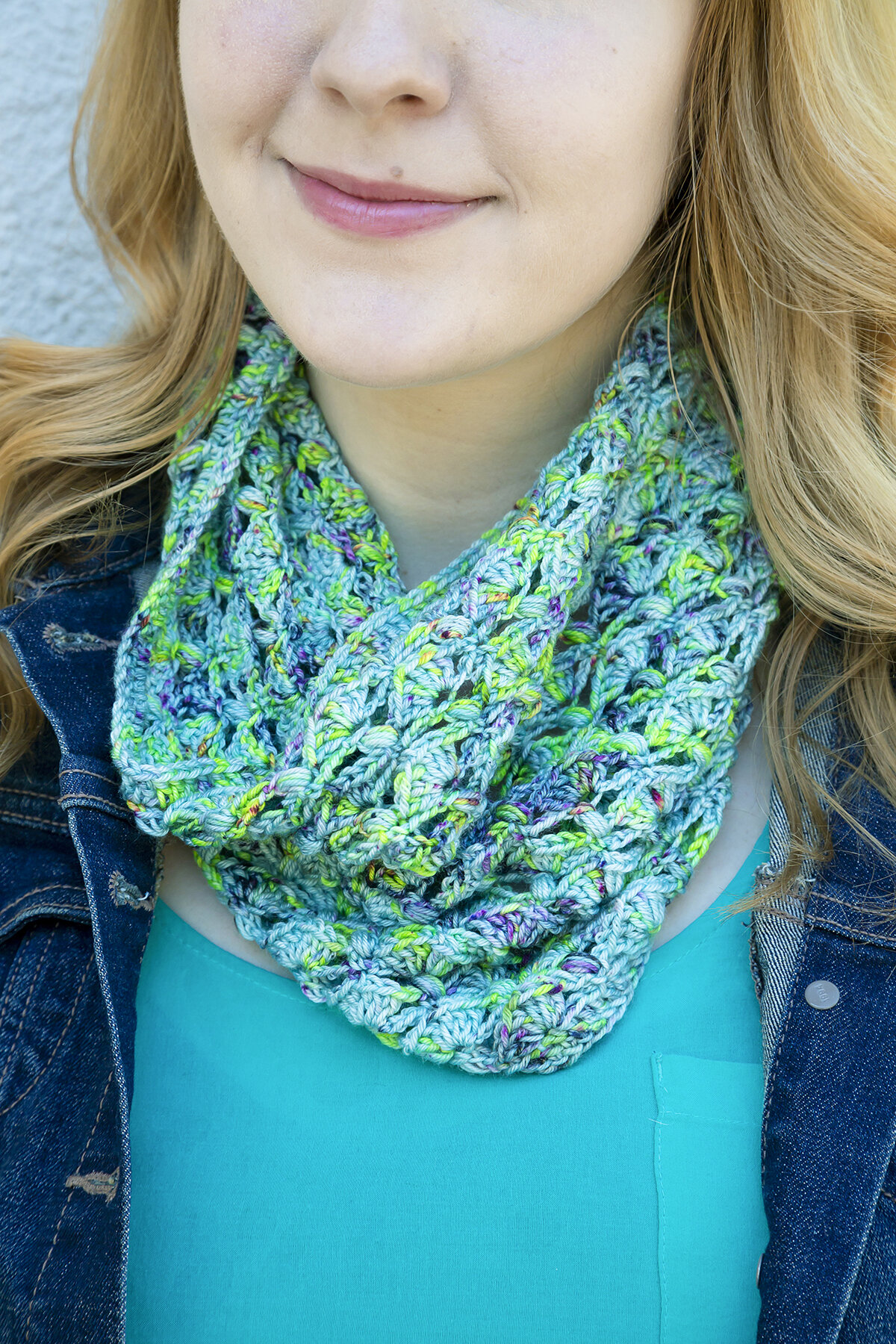  A close up view of the blue and green Anemone Cowl on a smiling woman. 