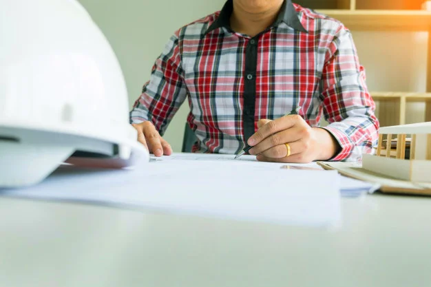 person-s-engineer-hand-drawing-plan-on-blue-print-or-working-project-in-his-office-with-architect-equipment_1423-1680 copy.jpg