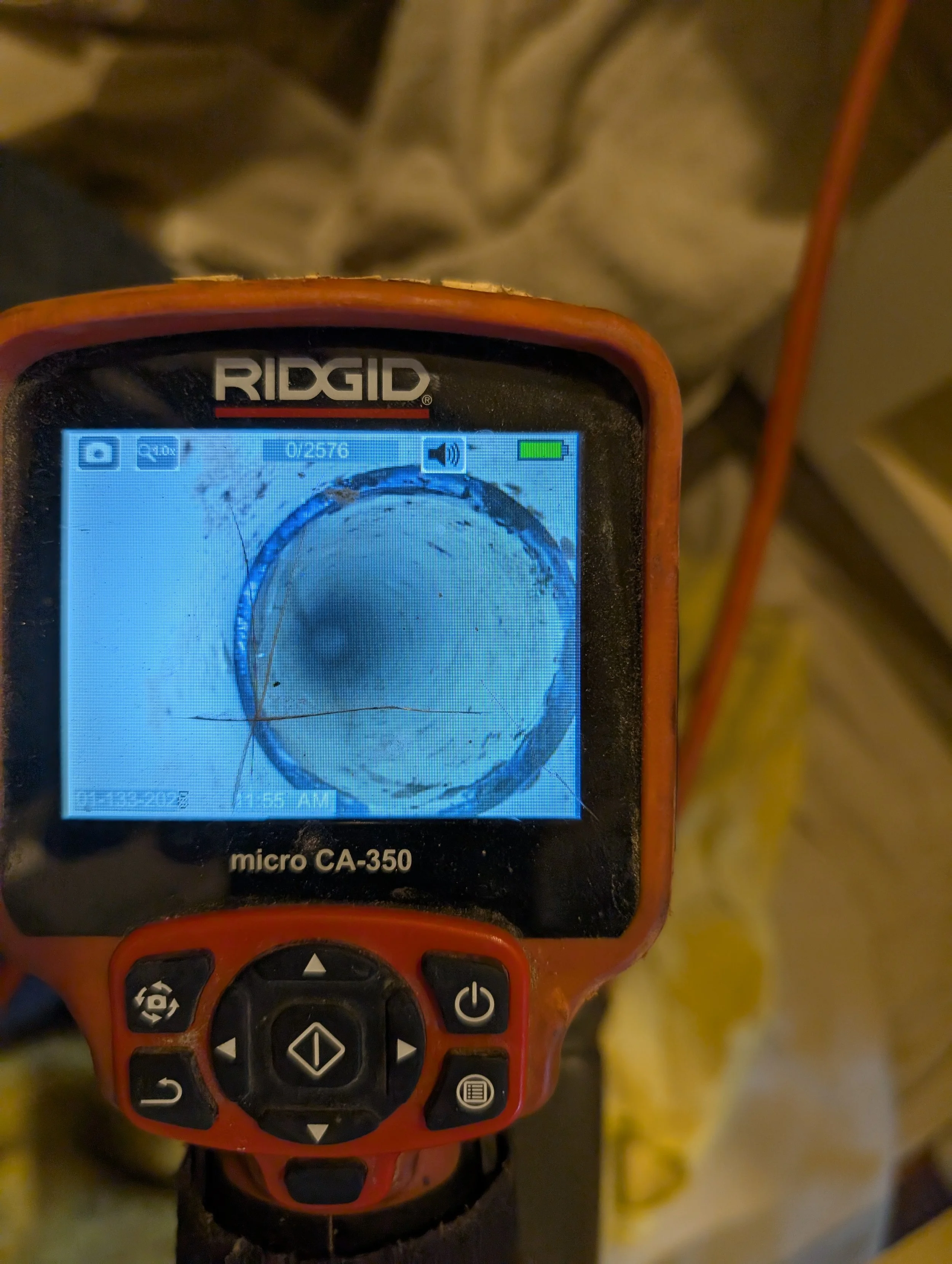 A laser level device showing a circular laser line with cracks visible on the screen.