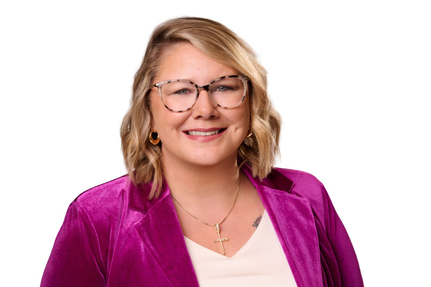 Executive Woman in pink blazer with blonde hair and fashionable eye glasses at a branded headshot booth setup at a Denver conference offering professional portraits for event guests at The Gaylord Rockies Conference Center in Aurora, Colorado..