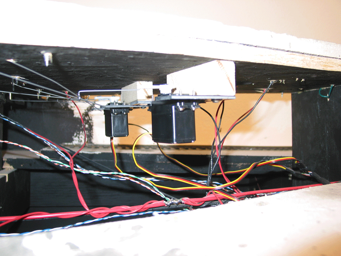 The retarders are model airplane servos and a simple bell-crank mechanism with piano wire through brass tubing into the end of the retarder, much like moving switch points. Depending upon the route selected, the Master and one Group retarder actuate when the button is pushed.