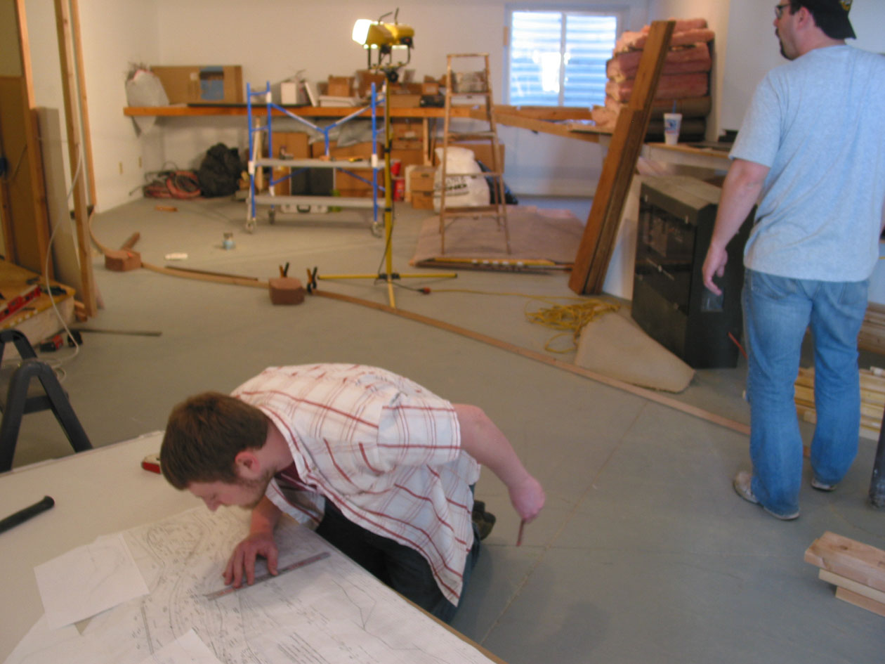  Kingston uses the scale rule to check the plan and locate the walls while Craig surveys the chaos. 