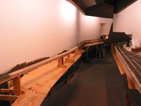  Plywood forms the future riverbed under a pin-connected truss and more distant, plate girder bridge. Lighting and valance have been added. Morrison is on the right of the aisle. 