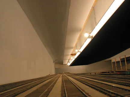 Lighting for 2.0 uses a combination of 4' electronic ballast florescent fixtures with Philips F32T8/TL930 bulbs and 35-50W 12v halogen white floods (fixture MR16). These are mounted on a light valance with the halogens spaced about 6' apart. As the photo shows, the florescents provide the overall lighting, and the low, angled halogens provide the sun shadows.