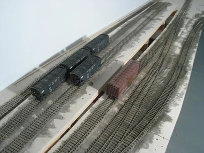 Hoppers sit at the site of the future Atomic Fuels operational coal loader. The box car is being held on the 2% grade by a retractable grade-brake. Also visible is the lengthening/relay of the Falls Church Branch off the NR&W as it exits into the aisle. Doing this will provide a place to hold cars when switching the Springs.