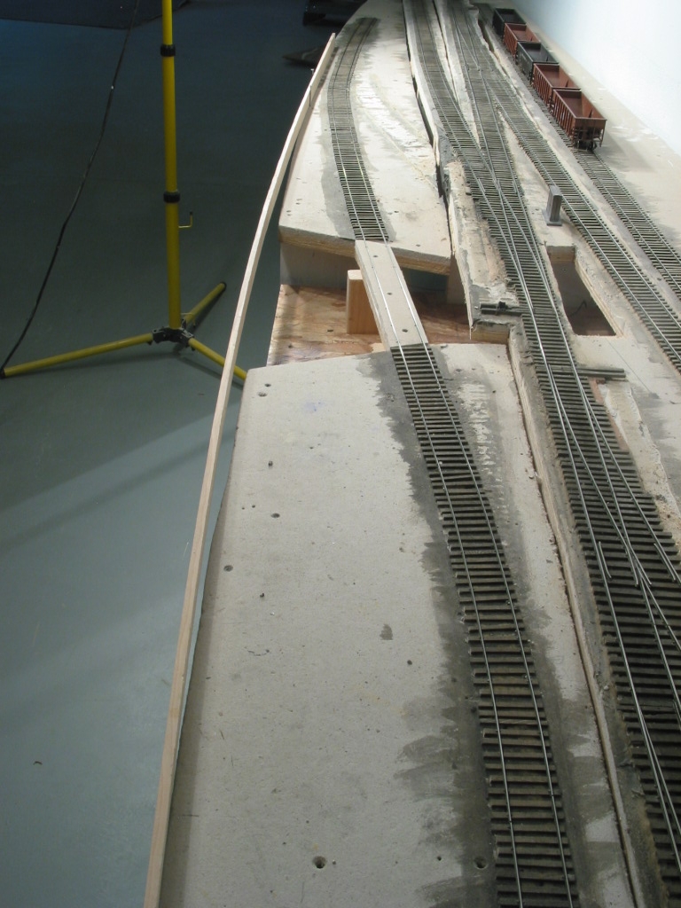 To create a smooth flowing edge for future fascia, a wood spline was initially set atop the plywood/micore base and a pencil line drawn. A saber saw completed job. A future pile trestle will carry a siding over the creek and be the main focus of thi