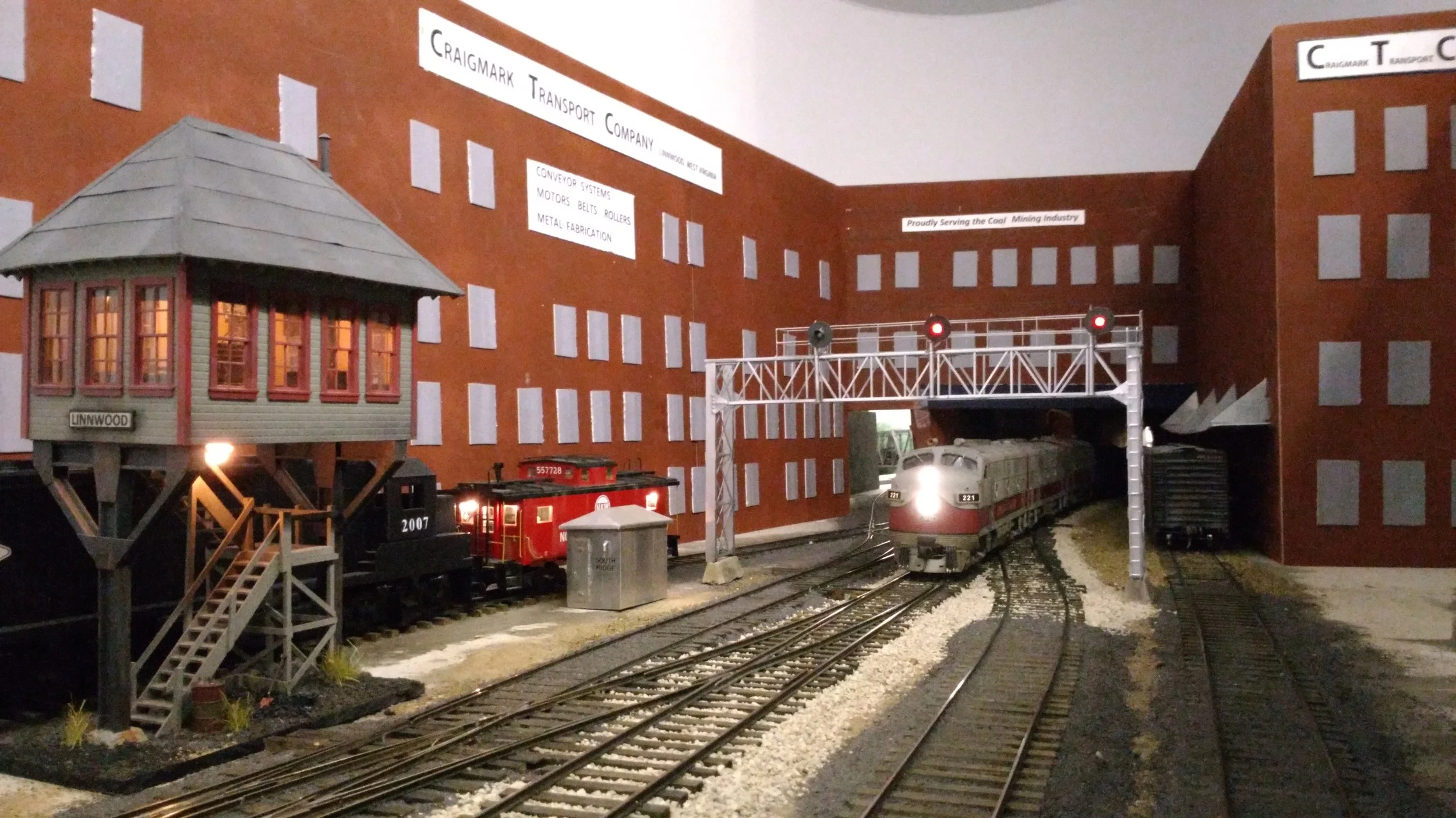 Finally. The train enters Linnwood, passing under a mock-up of Craigmark Transport Corp. (CTC :) This is the town where it's always raining,...and lightening, thanks again to the ingenuity of Bob Sobol.