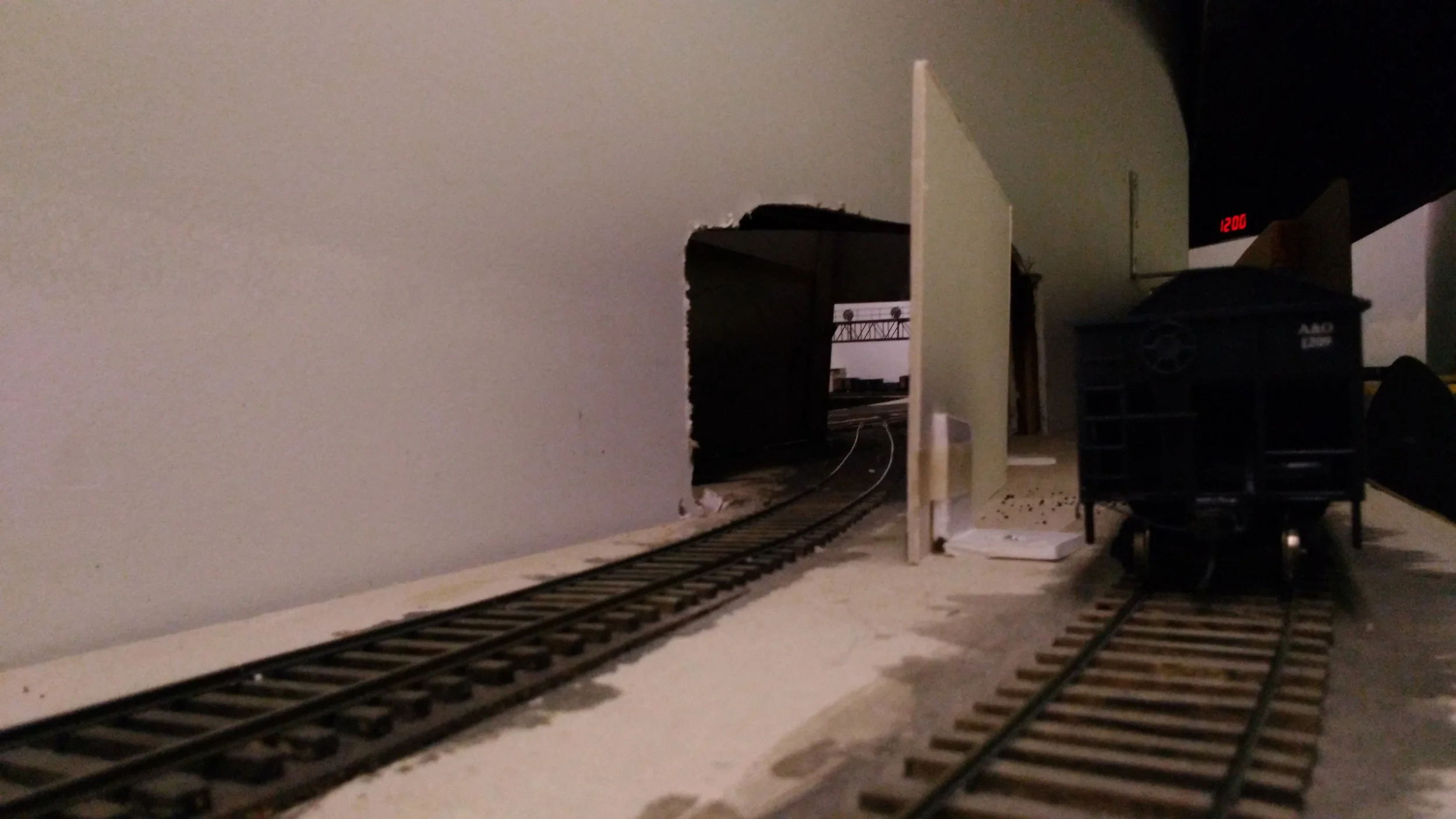 While this view thru the future tunnel will be blocked once scenery is in place, at the moment we can peep through into Linnwood Yard and see the signal bridge that gave us the "green" to begin our journey. Kayford is "dark territory" with traffic being managed by Track Warrant.